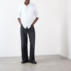Model wearing Burberry Sam Logo Check Trim Casual Shirt in Optic White with black wide-leg trousers and black chunky loafers.