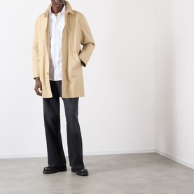 Model wearing Burberry Sam Logo Check Trim Casual Shirt in Optic White, styled with a beige mac coat, dark flared trousers and black loafers.