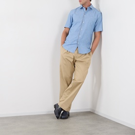 Model wearing Burberry Sam Check Trim Shirt in Stoke Blue Melange, short sleeves, button front, styled with beige chinos and dark shoes.