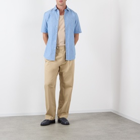 Model wearing Burberry Sam Check Trim Shirt in Stoke Blue Melange, short sleeves, styled with beige tee and khaki trousers.