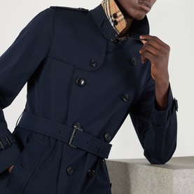 Model wearing Burberry Kensington Heritage Trench Coat in coal blue, double-breasted with epaulettes, leather-buckle belt and iconic check collar