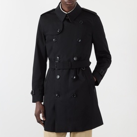 Model wearing Burberry Kensington Heritage Trench Coat in black, double-breasted with point collar, epaulettes, and matching belt.