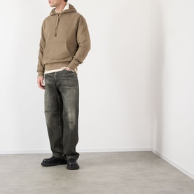 Model wearing Burberry finch brown cotton hoodie with half-zip, styled with dark distressed jeans and black boots.