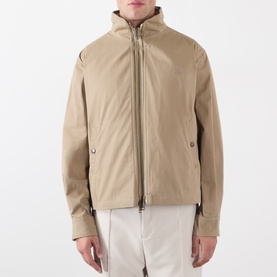 Model wearing Burberry saltmarsh beige cotton zip-up jacket with funnel neck, styled with white trousers.