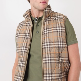 Model wearing Burberry saltmarsh beige check quilted gilet over olive green polo shirt, funnel neck, sleeveless style.