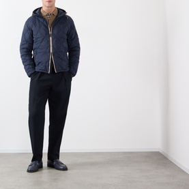 Model wearing Burberry navy quilted hooded jacket with black tailored trousers and dark leather shoes