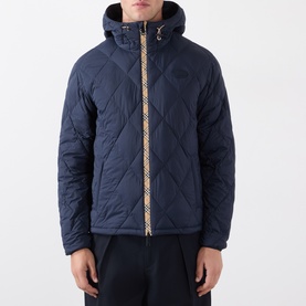 Model wearing Burberry navy quilted hooded jacket with signature check zip trim, styled with dark trousers.