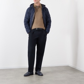 Model wearing Burberry navy quilted hooded jacket, styled with camel polo shirt, black trousers and dark leather shoes.