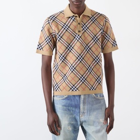 Model wearing Burberry Marlow Check Polo Shirt in sand IP check, short sleeves, polo collar with button fastenings, styled with light wash jeans.