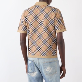 Model wearing Burberry Marlow Check Polo Shirt in sand IP check, rear view, styled with distressed light-wash jeans.