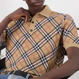 Model wearing Burberry Marlow Check Polo Shirt in Sand IP Check, featuring signature check pattern, polo collar and short sleeves. Styled with blue