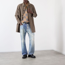 Model wearing Burberry Marlow Check Polo Shirt in Sand IP Check, styled with a taupe overcoat, light wash jeans and black loafers.