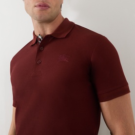 Model wearing Burberry red cotton polo shirt with tonal embroidered logo and checked placket detail, close-up shot