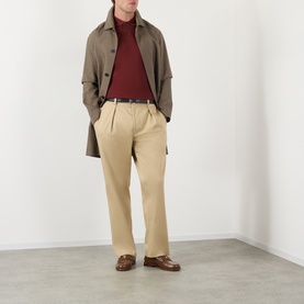 Model wearing Burberry red cotton polo shirt, styled with khaki trousers, brown loafers and an olive trench coat.