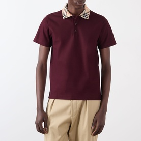 Model wearing Burberry Evan Check Polo Shirt in Vineyard Red with Burberry check collar, styled with beige trousers.