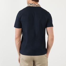 Model wearing Burberry Evan Burberry Check Polo Shirt in navy, rear view showing check collar detail, styled with beige chinos.