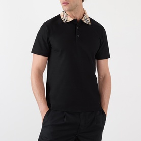 Model wearing Burberry black cotton polo shirt with signature check collar detail and three-button placket, styled with black trousers.