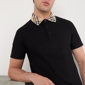 Model wearing Burberry black cotton polo shirt with signature check collar detail, short sleeves, and button placket.
