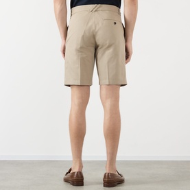 Model wearing Burberry Charlton Embroidered Logo Chino Shorts in Saltmarsh Beige, rear view, styled with tan loafers