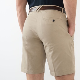 Model wearing Burberry Charlton Embroidered Logo Chino Shorts in Saltmarsh Beige, rear view, styled with brown leather belt and navy top