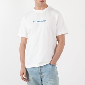 Model wearing Burberry white cotton T-shirt with blue logo print at chest, styled with light blue jeans