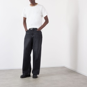 Model wearing Burberry Ryan Signature Check T-Shirt in white with black wide-leg jeans, belt, and chunky black loafers