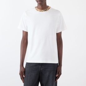 Model wearing Burberry Ryan Signature Check T-Shirt in white, featuring signature check taping at crew neck, styled with dark jeans.