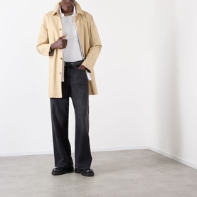 Model wearing Burberry Ryan Signature Check T-Shirt in white, styled with a stone trench coat and dark wide-leg jeans.
