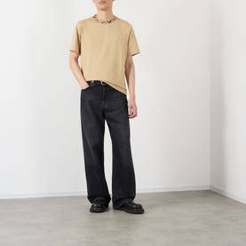 Model wearing Burberry Ryan Check-Collar T-Shirt in sand with black wide-leg jeans and black leather shoes.