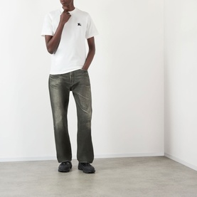 Model wearing Burberry Seth Embroidered Logo T-Shirt in white with crew neck, styled with khaki distressed jeans and black shoes.