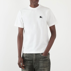 Model wearing Burberry Seth Embroidered Logo T-Shirt in white with EKG chest logo, styled with khaki jeans.