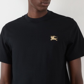 Model wearing Burberry Seth Embroidered Logo T-Shirt in black with gold EKD embroidered chest detail, crew neck, short sleeves.