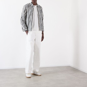 Model wearing Burberry Seth Logo Check T-Shirt in white, styled with check overshirt and white wide-leg trousers.