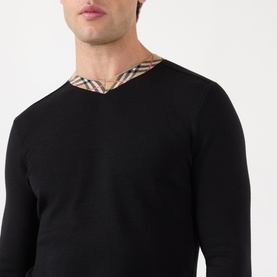 Model wearing Burberry black wool V-neck jumper with signature house check contrast collar trim detail.