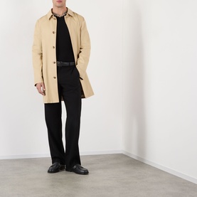 Model wearing Burberry Black Wool V Neck jumper, styled with a camel trench coat, black trousers, and black leather loafers.