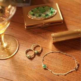 Daisy Jewellery Healing Stone Bobble Bracelet in 18ct gold plate with green aventurine stone, styled with matching rings and compact on wooden