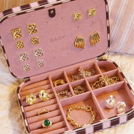 Daisy Jewellery Polly Large Jewellery Case in pink, open to reveal gold jewellery arranged in soft faux suede compartments with striped exterior