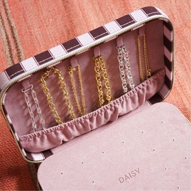 Daisy Jewellery Polly Large Jewellery Case in pink, open to reveal faux suede interior with gold necklaces displayed on bar hooks