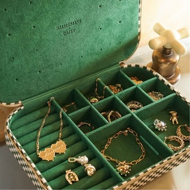 Daisy Jewellery Shrimps Large Jewellery Case in green, open to reveal velvet interior compartments filled with gold jewellery pieces