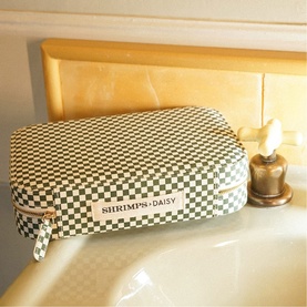Daisy Jewellery Shrimps Large Jewellery Case in green checkerboard print cotton with gold-tone zip, styled on a bathroom surface
