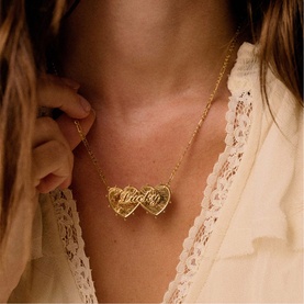 Model with Daisy Jewellery Shrimps Double Heart Lucky Necklace in 18ct gold plate, featuring entwined double heart pendant on fine chain