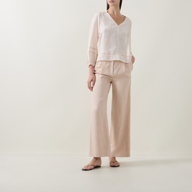 Model wearing InWear Vanilla blouse with V-neck and lace trim detail, styled with wide-leg blush trousers and flat sandals.