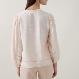 Model wearing InWear Vanilla blouse, back view, with lace-trim insert sleeves and relaxed balloon cuffs, styled with neutral trousers.