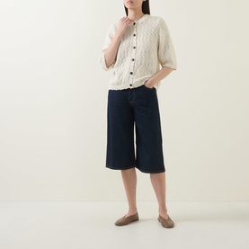 Model wearing InWear Dafne Textured Cardigan in Vanilla with short sleeves and button front, styled with dark denim culottes and taupe flats.
