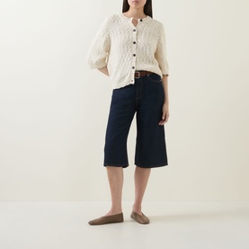 Model wearing InWear Dafne Textured Cardigan in Vanilla with round neck, short sleeves and button front, styled with navy cropped wide-leg trousers.