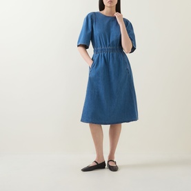 Model wearing InWear Glenn Denim Dress in Faded Blue, midi length with elasticated waist and short sleeves, styled with black flat shoes.