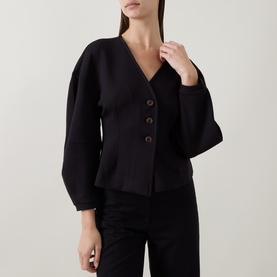 Model wearing InWear black jacket with V-neckline, tortoiseshell buttons, and balloon sleeves, styled with black trousers.