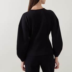 Model wearing InWear black jacket, rear view, with balloon sleeves and fitted silhouette, styled with black trousers.
