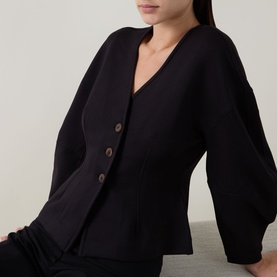 Model wearing InWear black jacket with V-neckline, button front fastening and wide balloon sleeves in a ribbed fabric.