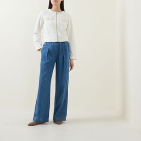Model wearing InWear Gladys Zip Denim Jacket in Ecru Melange, collarless with chest pockets, styled with wide-leg blue jeans and tan boots.